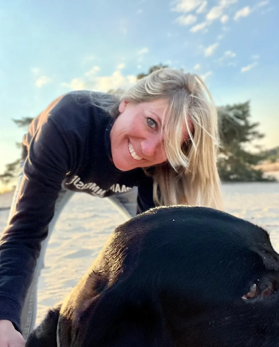 Angelique lachend met hond Finn aan het water
