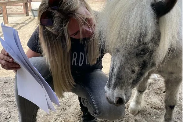 Angelique bespreekt haar aantekeningen bij een pony